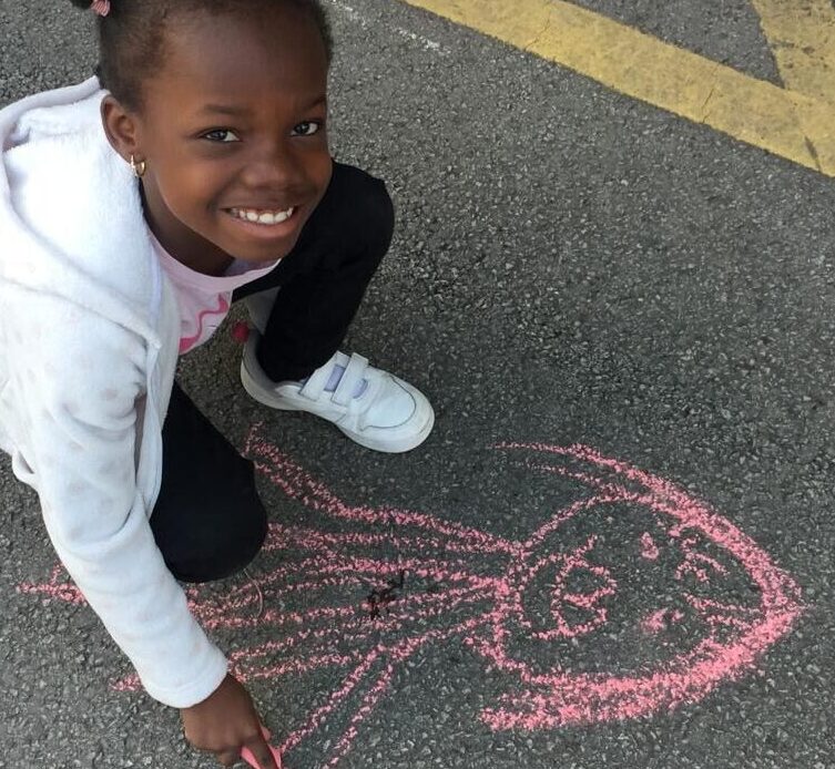Girl smiling with her chalk drawing