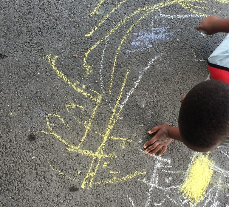 Child with their chalk drawing