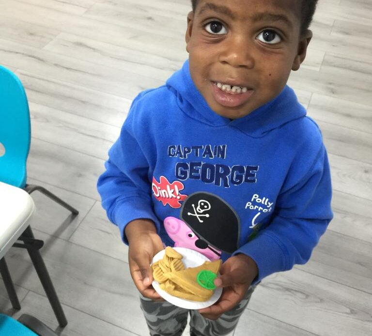 Child holding his playdough food creation