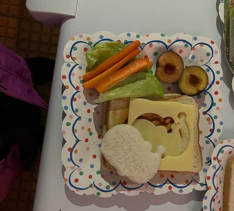 Beans and cheese toast with a snowman cut out. Carrot sticks, lettuce and plum as sides.