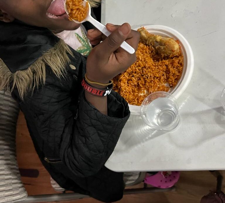 Child eating jollof rice and chicken